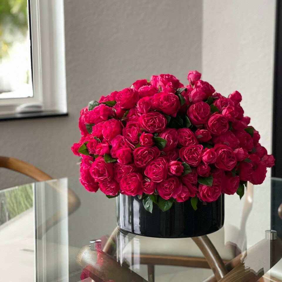 Rosas inglesas rosa escuro em vaso de vidro preto